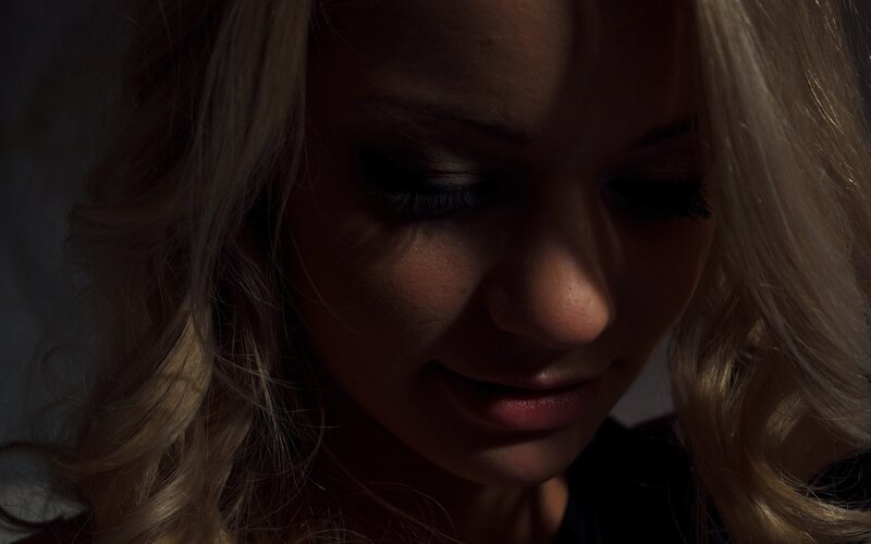 woman with blonde hair in dim light