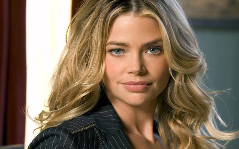 woman with blonde hair in pinstripe jacket