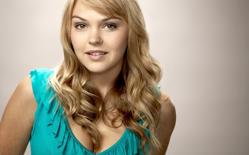 woman with blonde hair in teal top