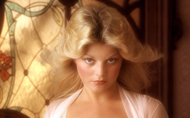 woman with blonde hair in white top