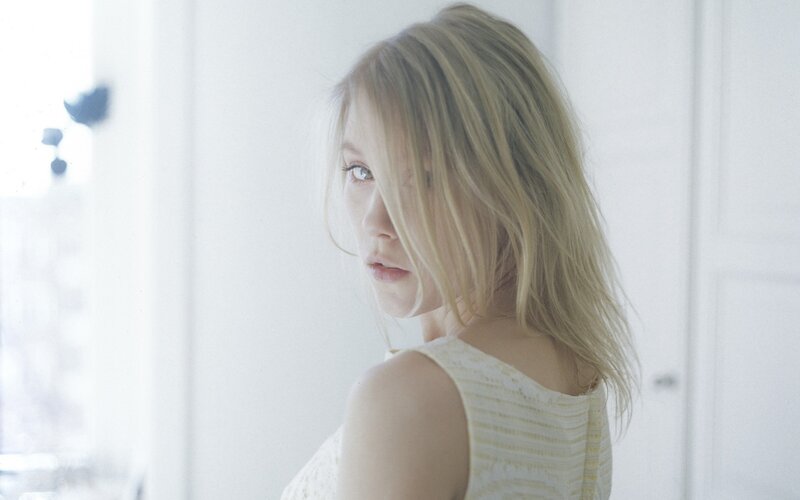 woman with blonde hair looking back