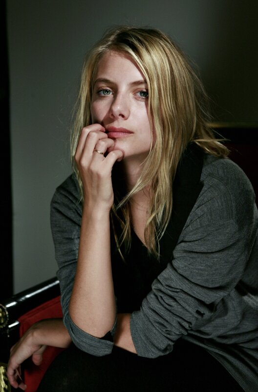 woman with blonde hair resting hand on chin