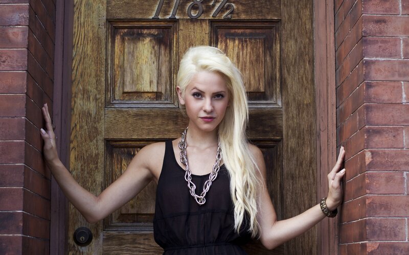 woman with blonde hair standing by door