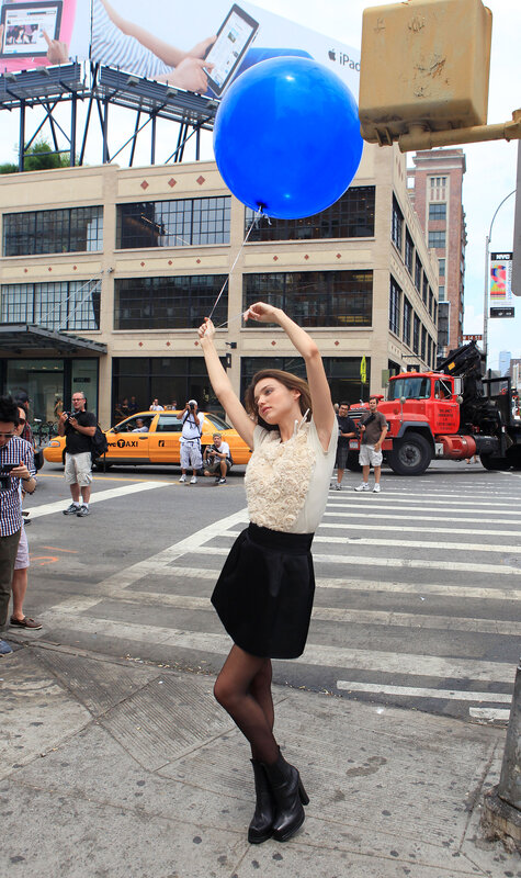 Woman with blue balloon on street