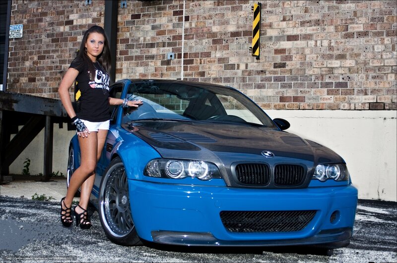 Woman with Blue Car — Confident, Afternoon, Photograph, Brick Wall