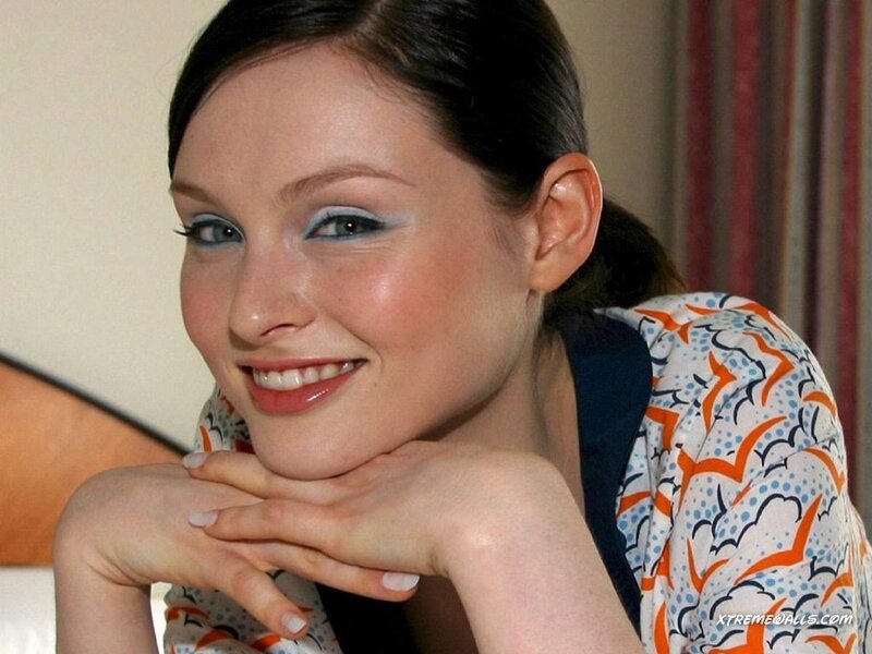woman with blue eye makeup smiling