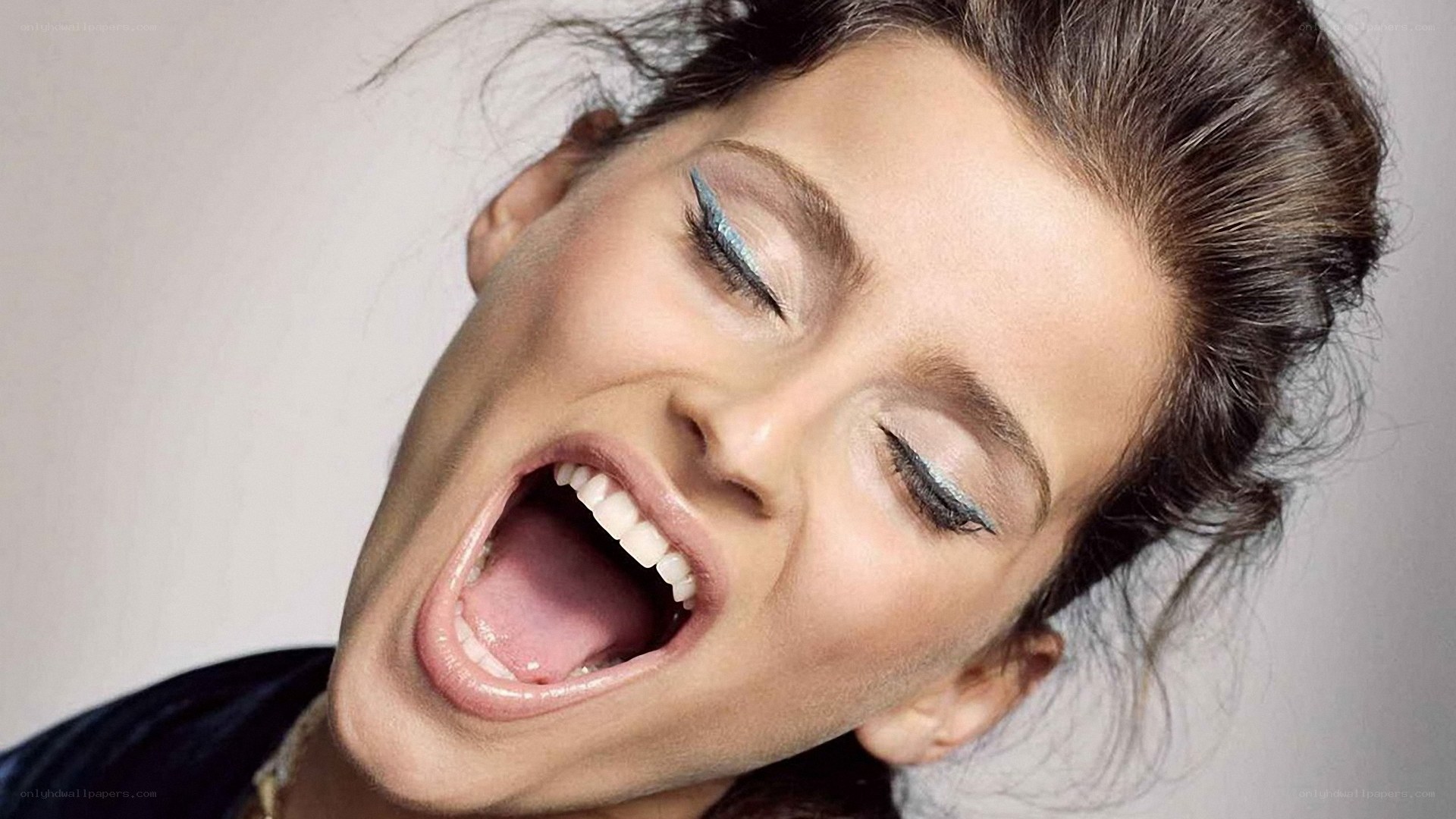 woman with blue eyeliner laughing