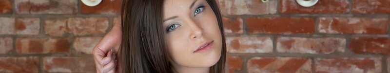 woman with blue eyes against brick wall