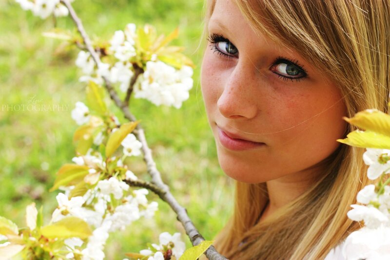 woman with blue eyes among blossoms