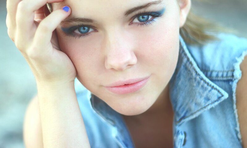 woman with blue eyes and denim vest