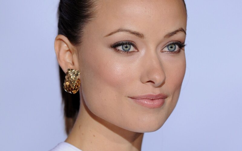 woman with blue eyes and gold earrings
