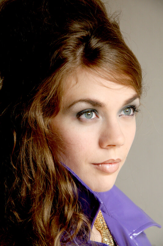 woman with blue eyes and purple jacket