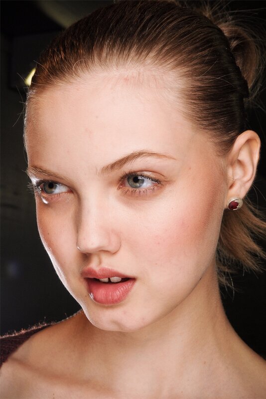 woman with blue eyes and red earring