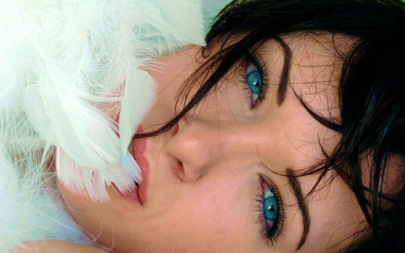 woman with blue eyes and white feathers