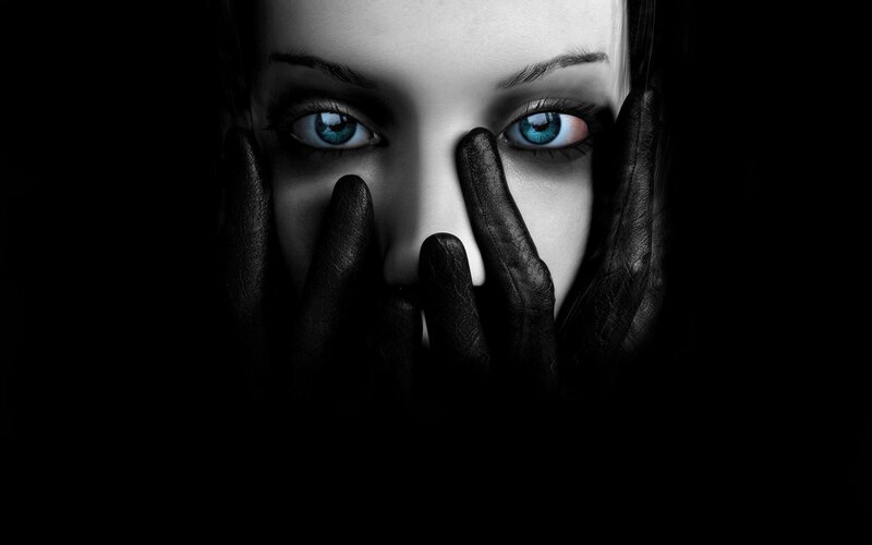 woman with blue eyes covering face