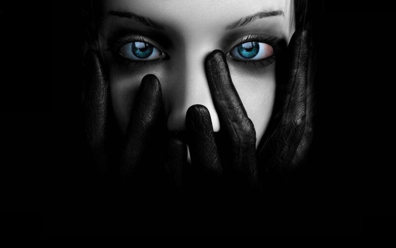 woman with blue eyes covering face