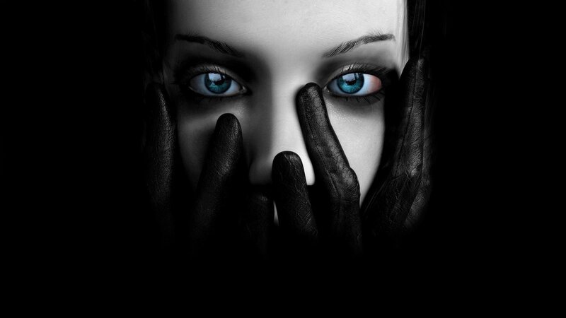 woman with blue eyes covering face