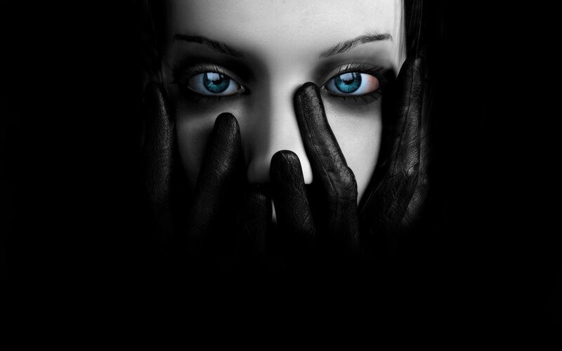woman with blue eyes covering face