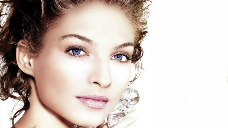 woman with blue eyes holding diamond