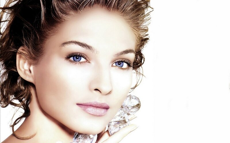 woman with blue eyes holding diamond