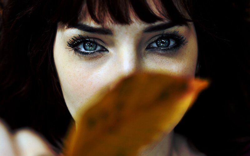 woman with blue eyes holding leaf