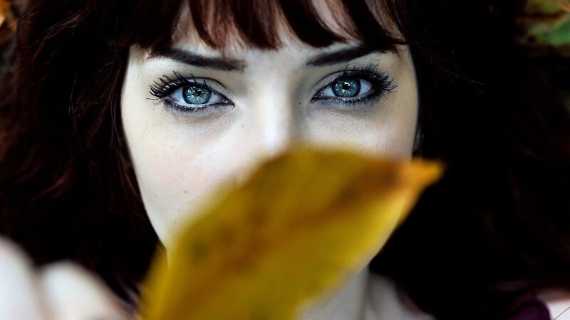 woman with blue eyes holding leaf
