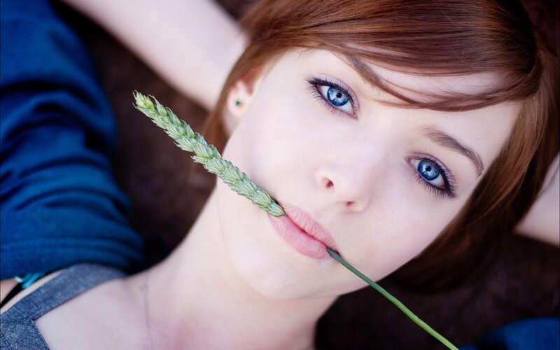 woman with blue eyes holding wheat