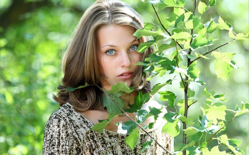 woman with blue eyes in green foliage