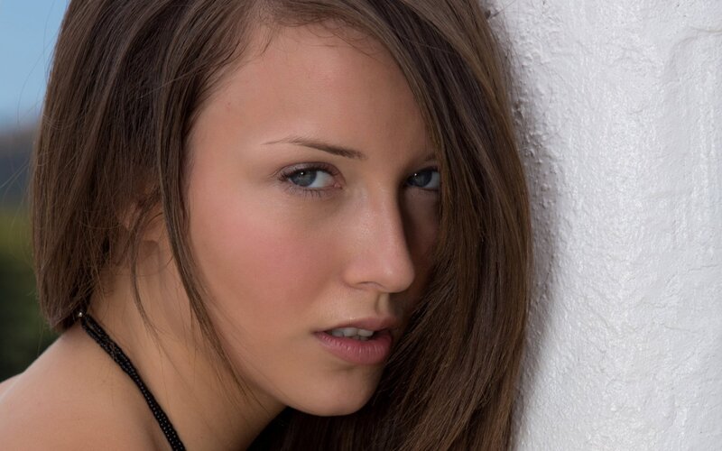 woman with blue eyes leaning on wall
