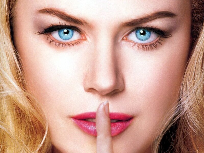 woman with blue eyes making shush gesture