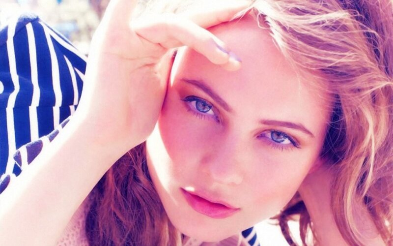 woman with blue eyes shielding sun
