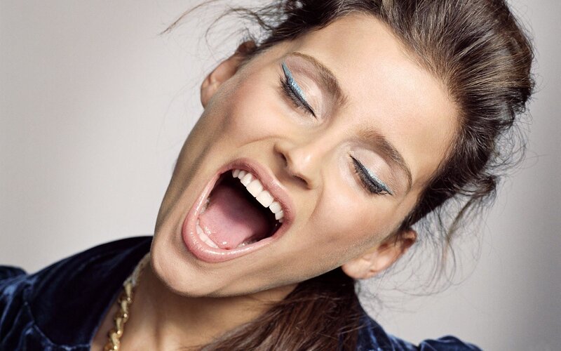woman with blue eyeshadow laughing