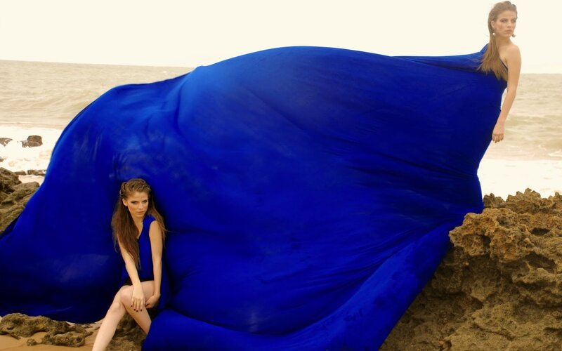 Woman with blue fabric on beach