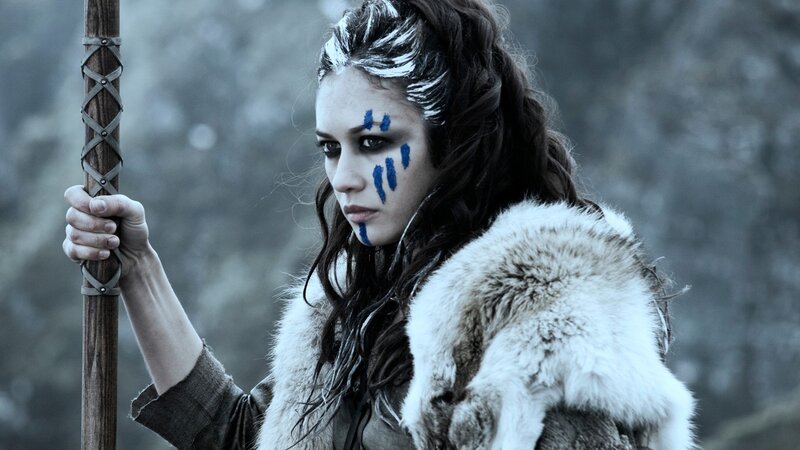 woman with blue face paint holding staff