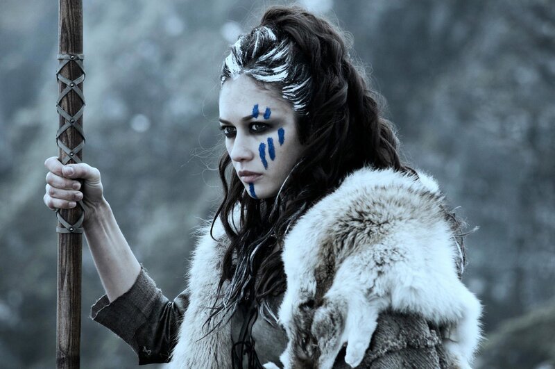 woman with blue face paint holding staff