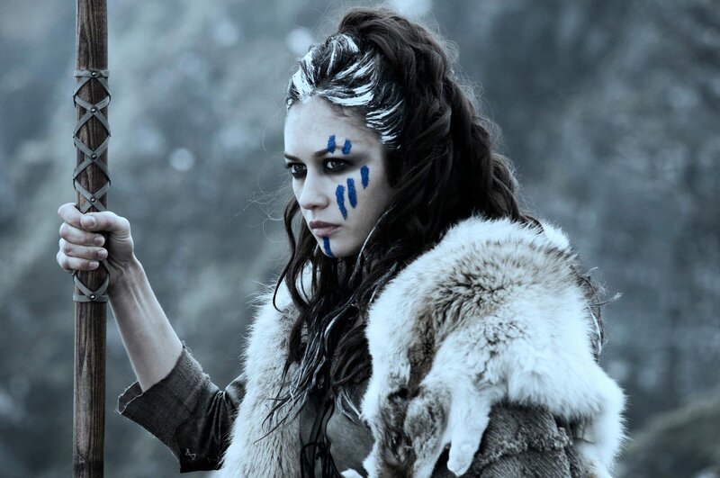 woman with blue face paint holding staff