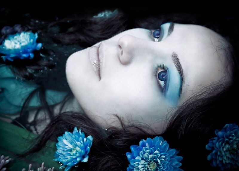 woman with blue flowers in water