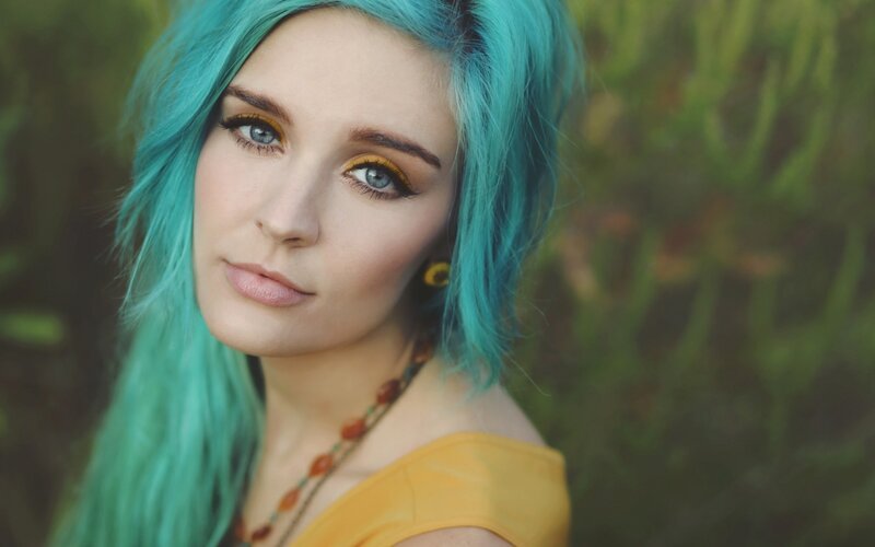 woman with blue hair and yellow makeup