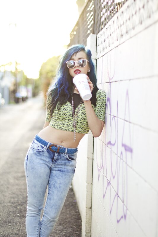 woman with blue hair drinking coffee