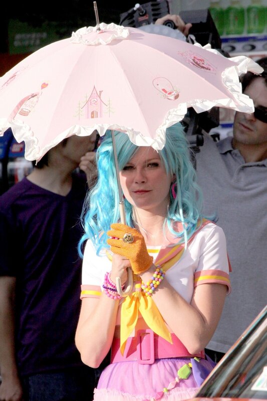 woman with blue hair holding pink umbrella