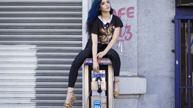 woman with blue hair on payphone