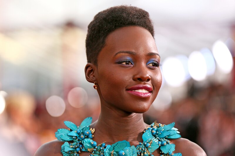 woman with blue makeup and floral necklace