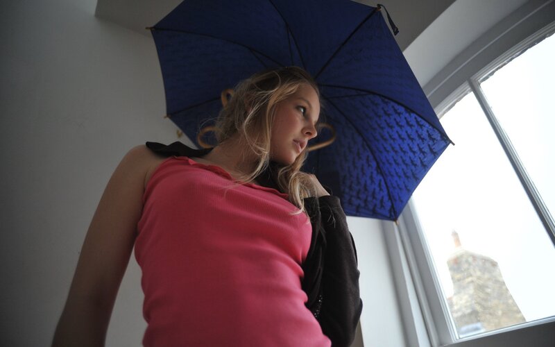 Woman with blue umbrella indoors