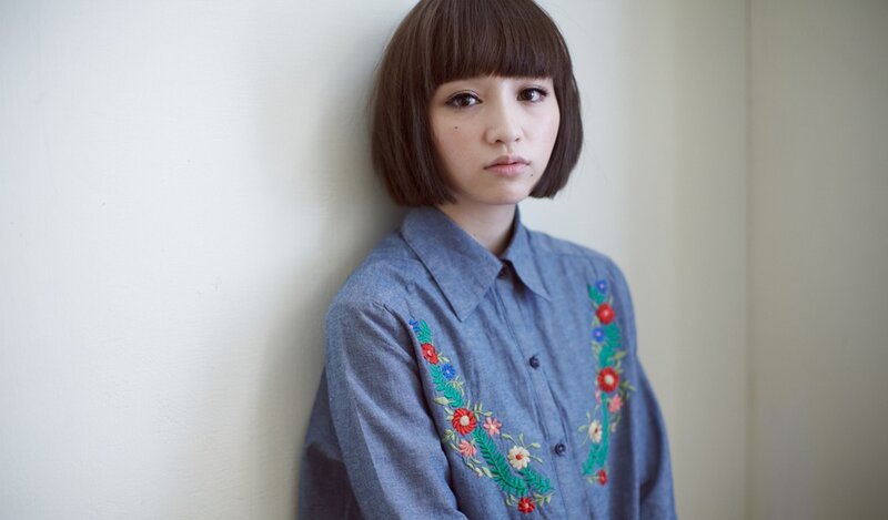woman with bob haircut and embroidered shirt
