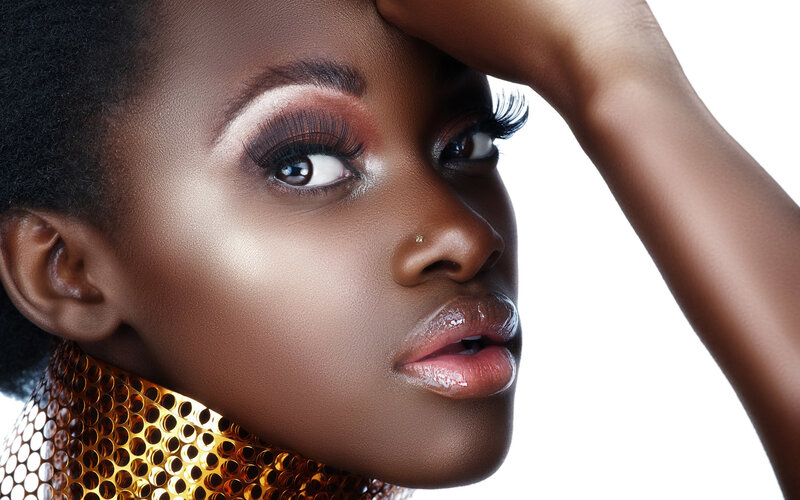 woman with bold makeup and gold collar