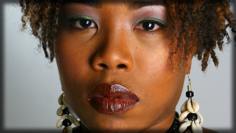 woman with bold makeup and shell earrings