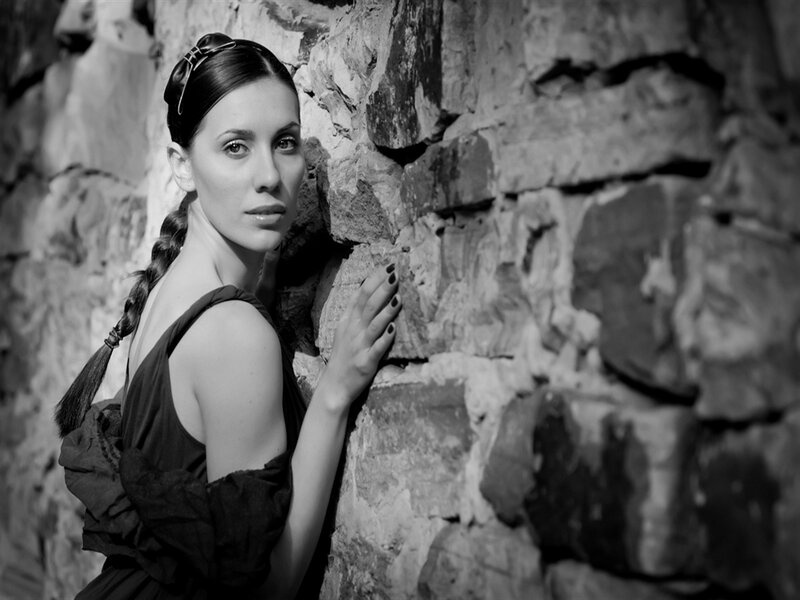 Woman with Braided Hair — Black, Dramatic, Photograph, Stone Wall