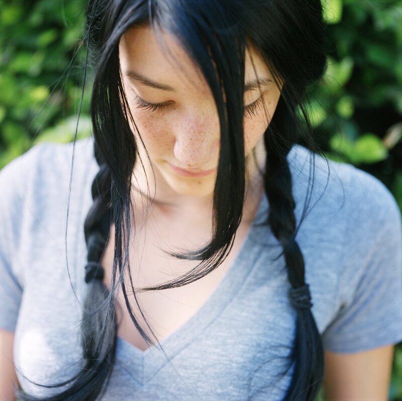 woman with braided hair looking down