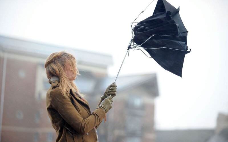 Woman with broken umbrella in storm