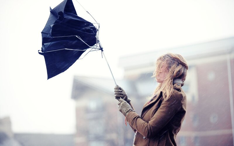 Woman with broken umbrella in storm